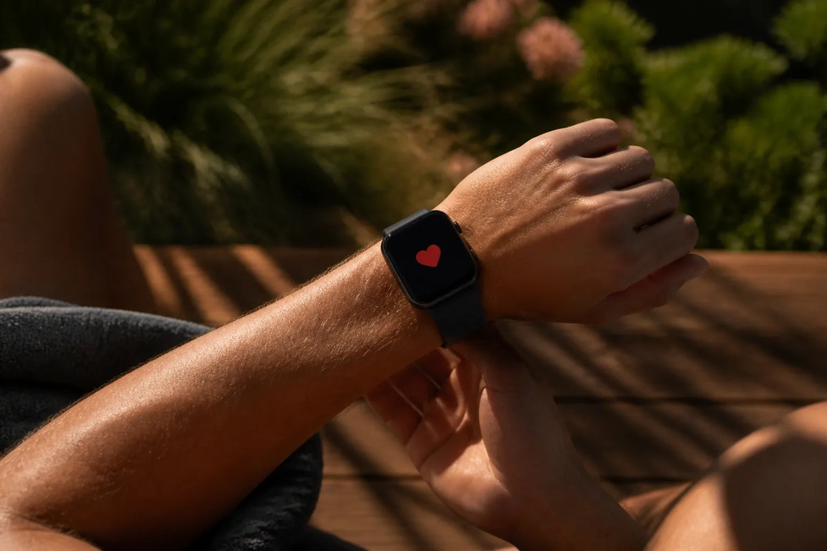 Barrel 250 - buitensauna voor 6-8 personen met een close-up van een smartwatch die alleen een rood hartsymbool toont