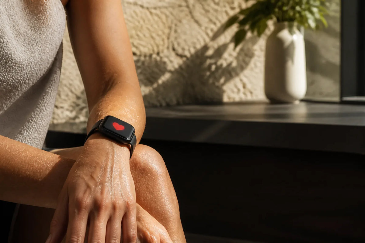 Nero 210 - binnensauna voor 3-4 personen met een close-up van een smartwatch die alleen een rood hartsymbool toont