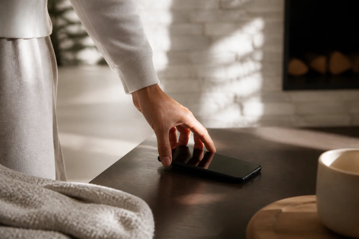 Nero 220 - binnensauna voor 6 personen in een scène van mentale rust met een telefoon met het scherm naar beneden op tafel
